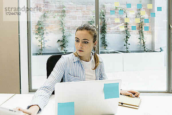 Weibliche Fachkraft mit Laptop bei der Arbeit im Büro