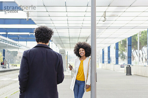 Afro-Frau sieht männlichen Freund am Bahnhof an