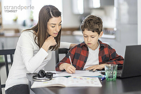 Frau hilft ihrem Sohn beim Lernen zu Hause