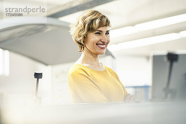 Lächelnde reife Geschäftsfrau in einer Druckerei
