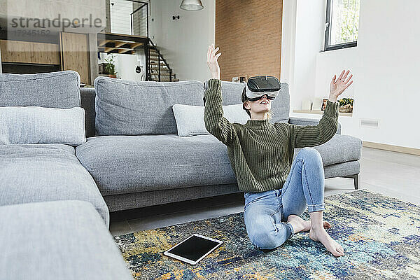 Frau mit Virtual-Reality-Headset im heimischen Wohnzimmer