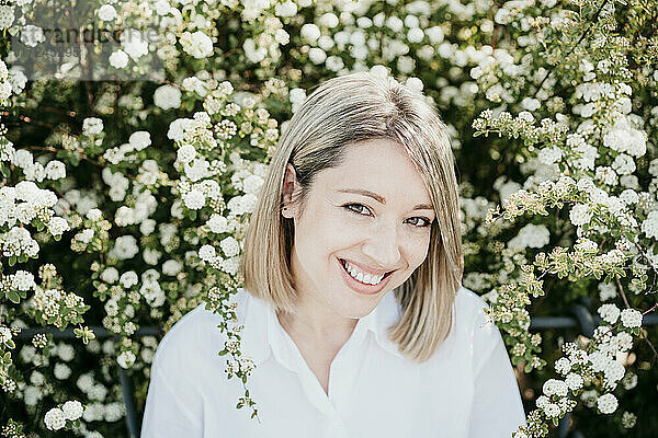 Lächelnde Frau inmitten von weißen Blumen
