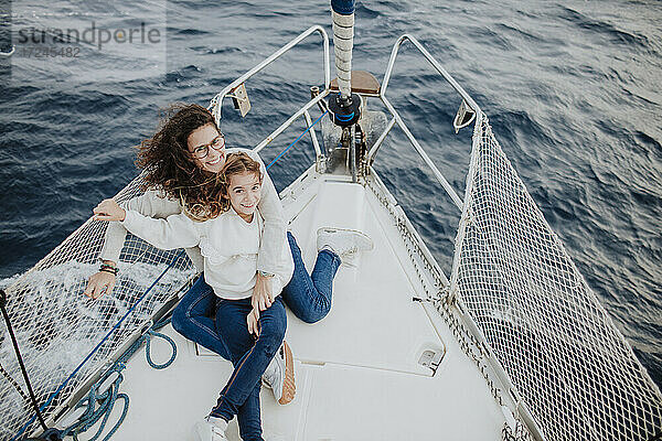 Lächelnde Mutter und Tochter genießen den Urlaub auf einem Segelboot