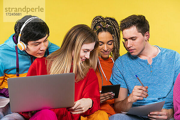 Junge Freunde  die gemeinsam über ein digitales Tablet lernen