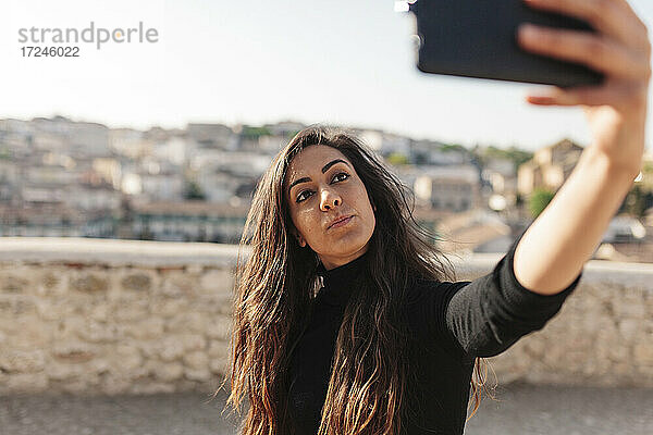 Frau nimmt Selfie durch Smartphone an einem sonnigen Tag