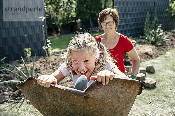 Glückliche Enkelin spielt mit Großmutter im Hinterhof