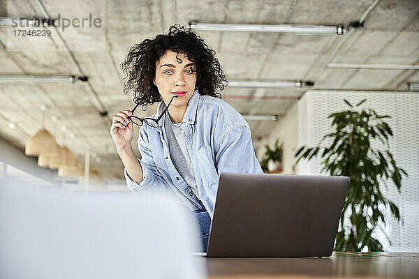 Frau mit Laptop und Brille im Loft