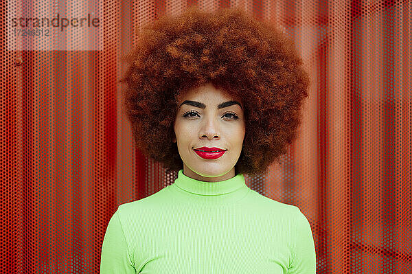Schöne Afro-Frau vor roter Wand
