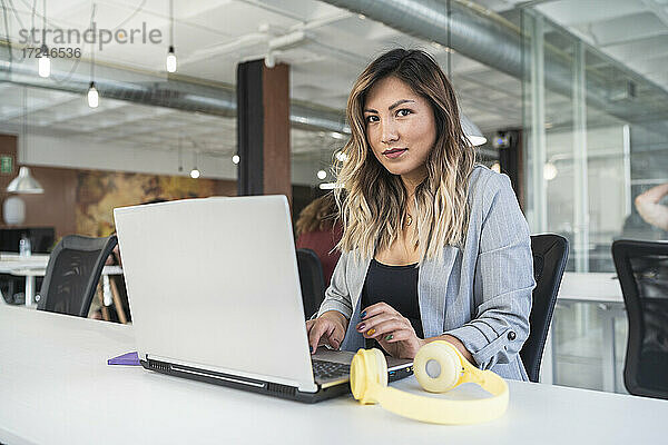 Geschäftsfrau arbeitet an einem Laptop in einem Coworking-Büro