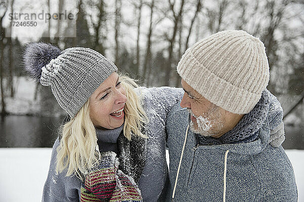 Glückliche Frau umarmt Mann im Winter