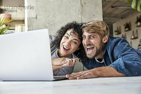 Lachendes Paar bei der gemeinsamen Nutzung eines Laptops