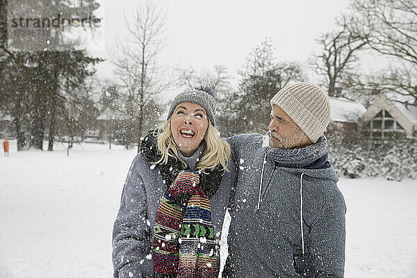 Mann und Frau vergnügen sich im Winter im Schnee