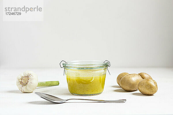 Suppe mit Gemüse und Löffel auf weißem Hintergrund