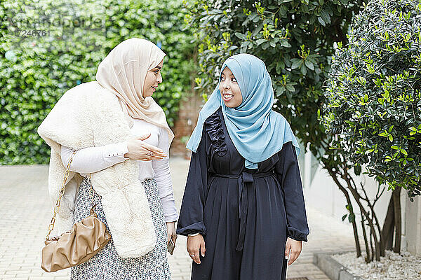 Freundinnen mit Hidschab  die sich auf dem Gehweg unterhalten