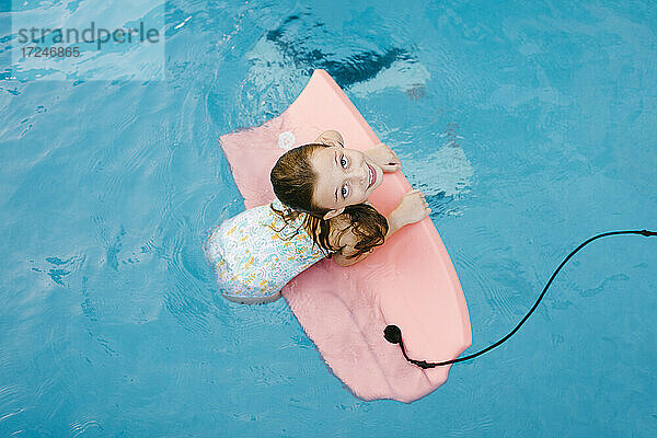 Mädchen spielt mit Schwimmflügel im Wasser