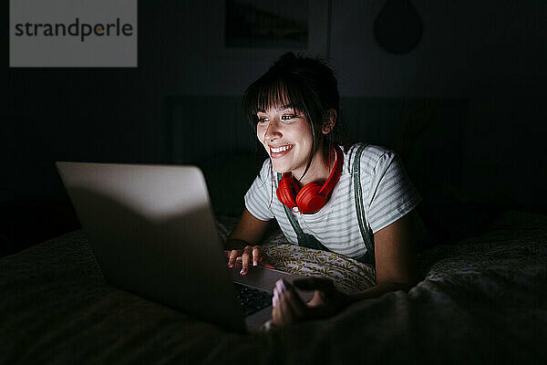 Lächelnde Frau beim Betrachten eines Films in der Dunkelkammer