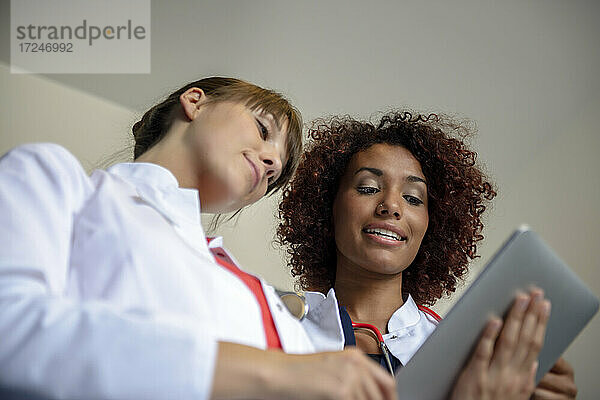 Ein Team von weiblichen Fachkräften diskutiert über ein digitales Tablet im Krankenhaus