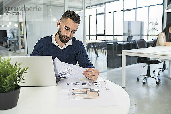 Männlicher Fachmann  der ein Dokument in einem Coworking-Büro liest