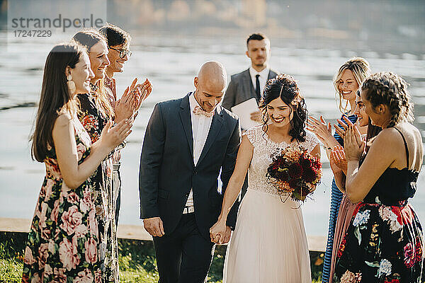Hochzeitsgäste applaudieren dem Paar bei der Trauung