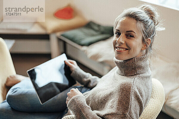 Lächelnde Frau mit digitalem Tablet in einem Cafe