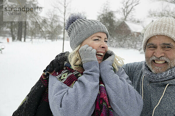 Fröhliche Frau und Mann in warmer Kleidung im Park im Winter