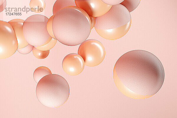 Dreidimensionales Rendering von rosa und orangefarbenen Kugeln  die vor einem rosa Hintergrund schweben