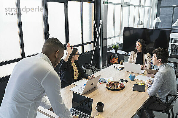 Multiethnische Unternehmer und Unternehmerinnen diskutieren bei einem Treffen im Coworking-Büro