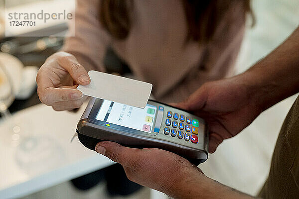 Frau bezahlt mit Kreditkarte im Restaurant