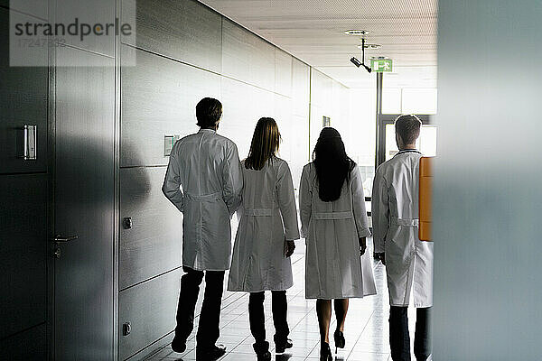 Weibliche und männliche Ärzte im Laborkittel gehen zusammen im Krankenhaus