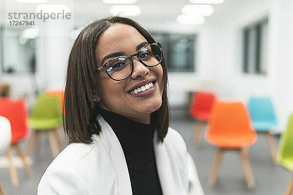 Geschäftsfrau mit Brille lächelt im Klassenzimmer