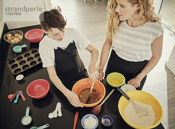 Junge lernt mit seiner Mutter in der Küche zu Hause die Zubereitung von Speisen