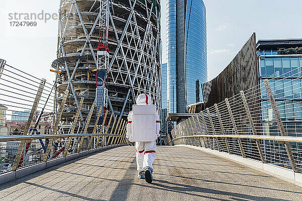 Männlicher Astronaut auf einer Brücke in der Stadt