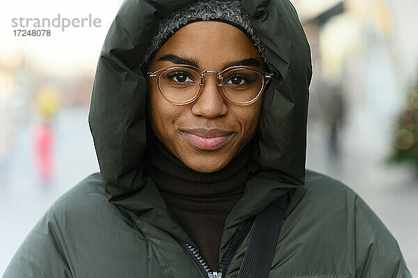 Lächelnde Frau mit Brille und warmer Kleidung