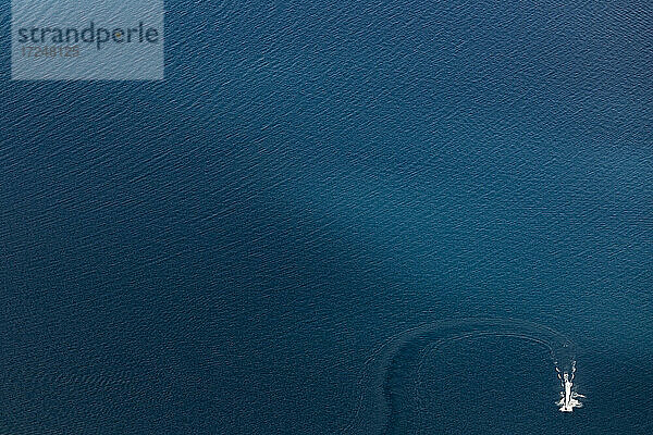 Luftaufnahme der blauen Oberfläche des Hawea-Sees mit Jetboot in der Ecke