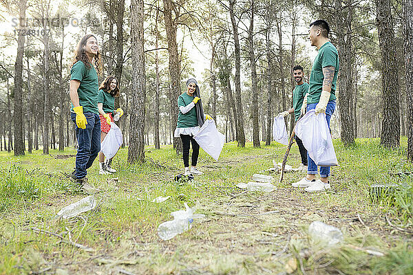 Umweltschützer stehen mit Plastikmüll im Wald