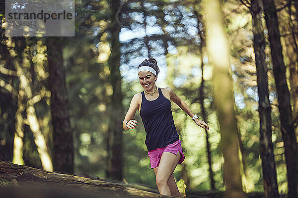Lächelnde Sportlerin beim Laufen im Wald