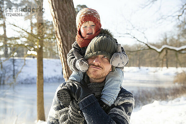 Vater trägt seinen Sohn im Winter auf der Schulter