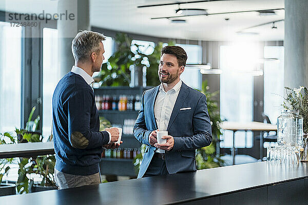 Geschäftsleute unterhalten sich bei einem Kaffee im Bürocafé