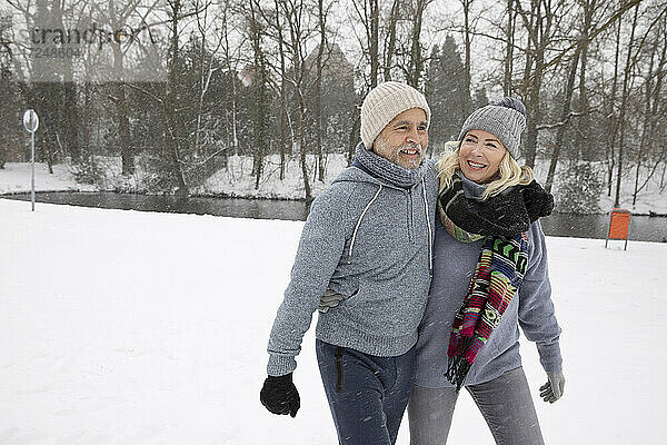 Älterer Mann mit Arm um Frau  die im Park spazieren geht