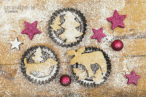 Weihnachtsdekoration und frische  selbstgebackene Kekse auf einer Holzunterlage