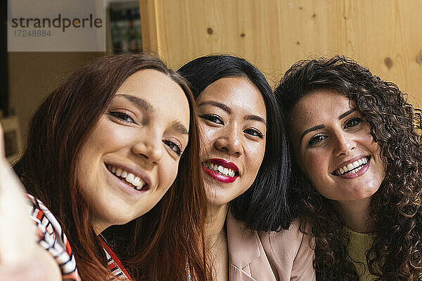 Junge Frauen nehmen Selfie durch Handy zusammen im Café