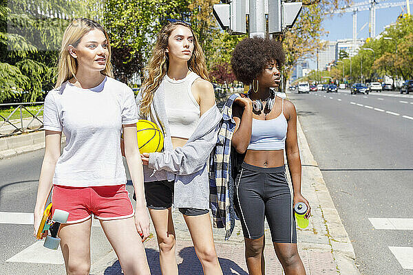 Junge Frauen schauen weg  während sie auf dem Gehweg stehen