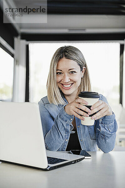 Lächelnde Unternehmerin bei einem Kaffee im Geschäft