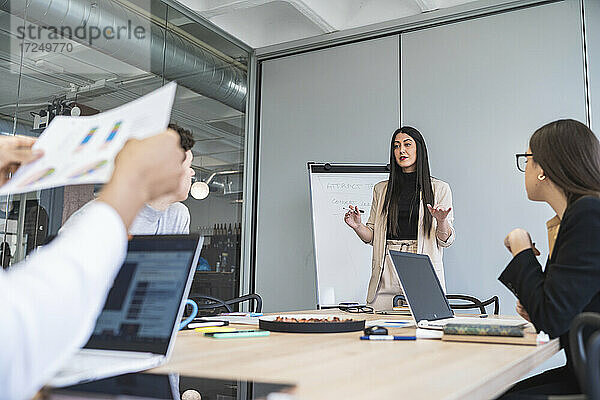 Unternehmerin gestikuliert bei der Erläuterung einer Strategie während einer Besprechung im Büro