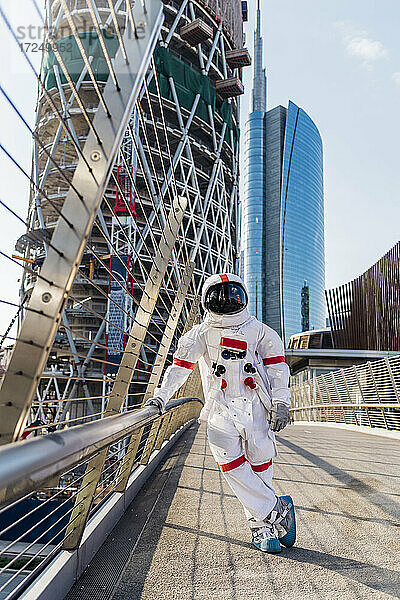 Männlicher Astronaut auf einem Bein stehend auf einer Brücke
