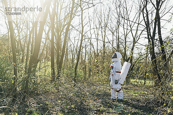 Junger Astronaut auf der Suche im Wald an einem sonnigen Tag