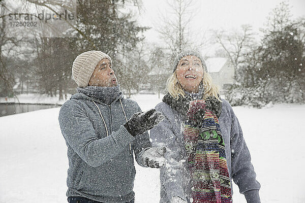 Älteres Paar wirft Schnee beim Spielen im Winter