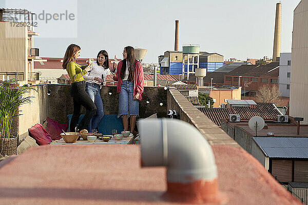 Freundinnen unterhalten sich auf dem Dach stehend