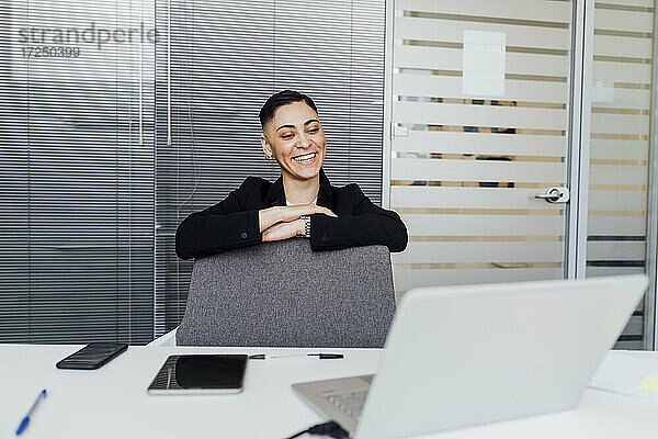 Weibliche Fachkraft lächelt während eines Videoanrufs am Laptop im Büro