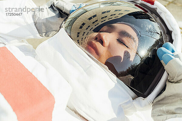 Weibliche Astronautin mit Helm im Liegen in der Stadt